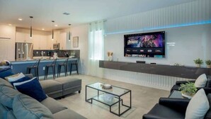 Ein modernes Wohnzimmer mit Sofa, Couchtisch und Wandfernseher.