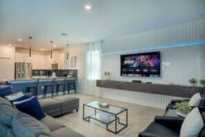 Ein modernes Wohnzimmer mit Sofa, Couchtisch und Wandfernseher.