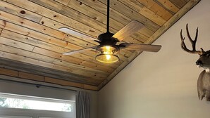 A room with a wooden ceiling, a bed with a patterned blanket, a lamp, and a deer head on the wall. - Almost Heaven: Aspen Season in the Colorado Mountains (Fort Garland)