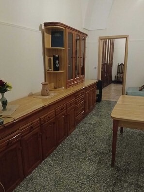 Eine Küche mit Holzausstattung, einer Granit Arbeitsplatte und einem Esstisch.