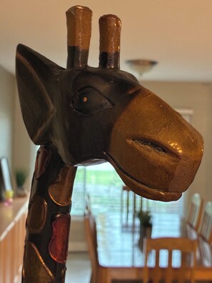 Eine Giraffenskulptur mit dunklem Gesicht und goldenen Hörnern.