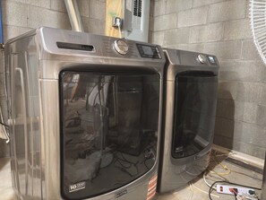 Two stacked Maytag washers with a control panel, a power outlet, and a 10-year warranty sticker.