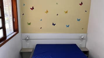 A small room with a bed, a window, and a wall with butterfly decals.