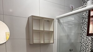 Un baño con inodoro, lavamanos, ducha y espejo.