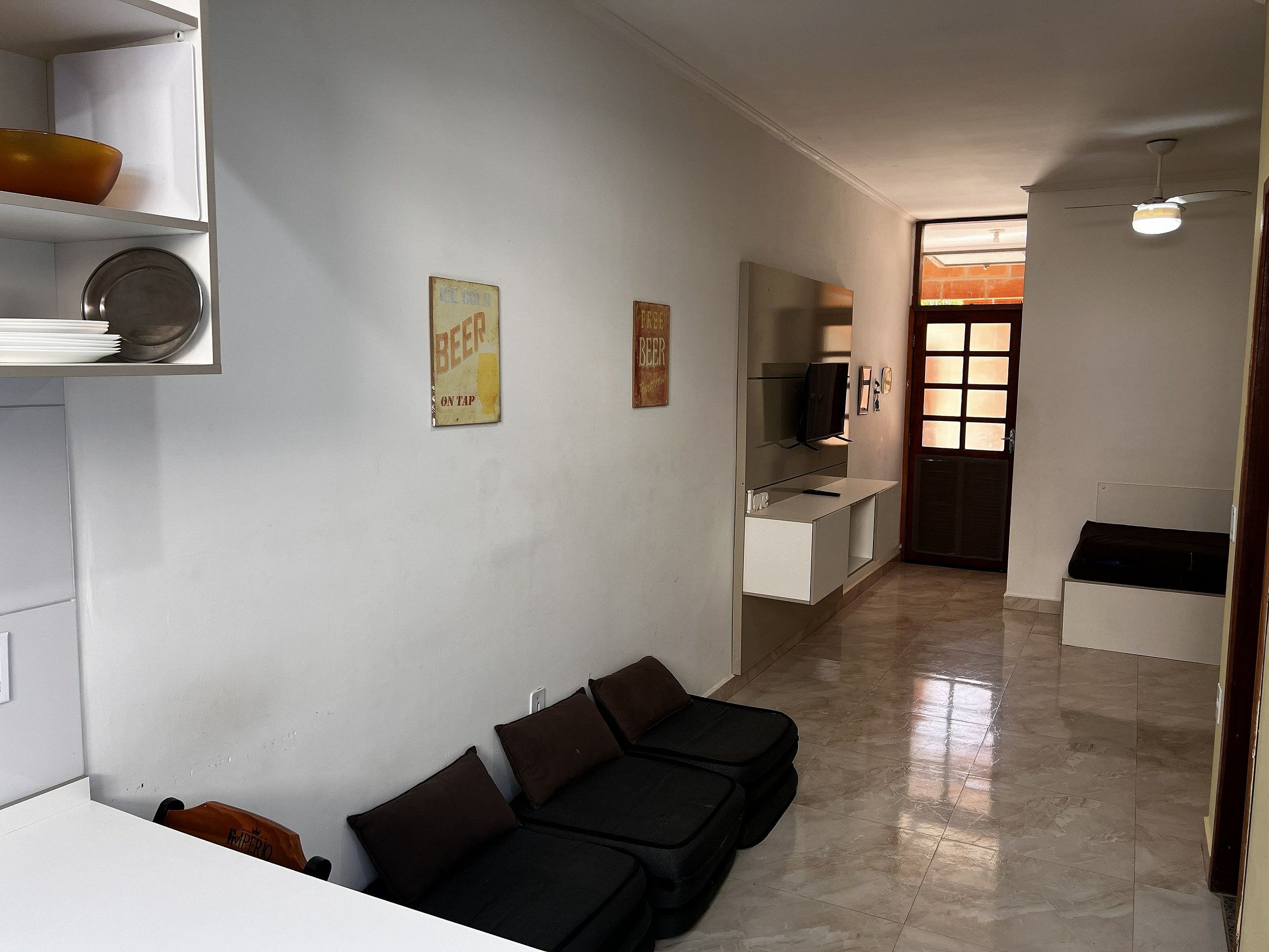 Una sala de estar con un sofá, un televisor y una estantería de pared.