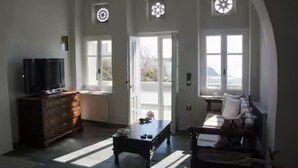Une pièce comprenant une télévision, un meuble en bois foncé, une table basse, un canapé et une fenêtre donnant sur un beau paysage.