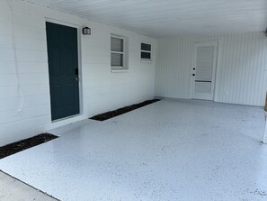 A house with a dark green door, white siding, and a concrete porch. - 10 Min to Gulf Coast Beaches - Pet Friendly - Fenced Yard (Seminole)