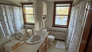 Un baño pequeño con lavabo, inodoro y zona de ducha.