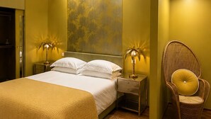 Een slaapkamer met een bed, twee nachtkastjes met lampen, een stoel en een behang met patroon.