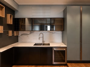 A modern kitchen with a marble countertop, built-in cabinets, a stainless steel sink, and a built-in oven. - Luxury beachfront apartment (Napoli)