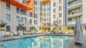 A modern hotel with a swimming pool, lounge chairs, and a covered seating area. - Apartment located in downtown Los Angeles across from the convention center (Los Angeles)