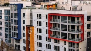 A multi-story hotel with a modern design, featuring a prominent vertical wooden column and a red accent on the upper level. - Apartment located in downtown Los Angeles across from the convention center (Los Angeles)