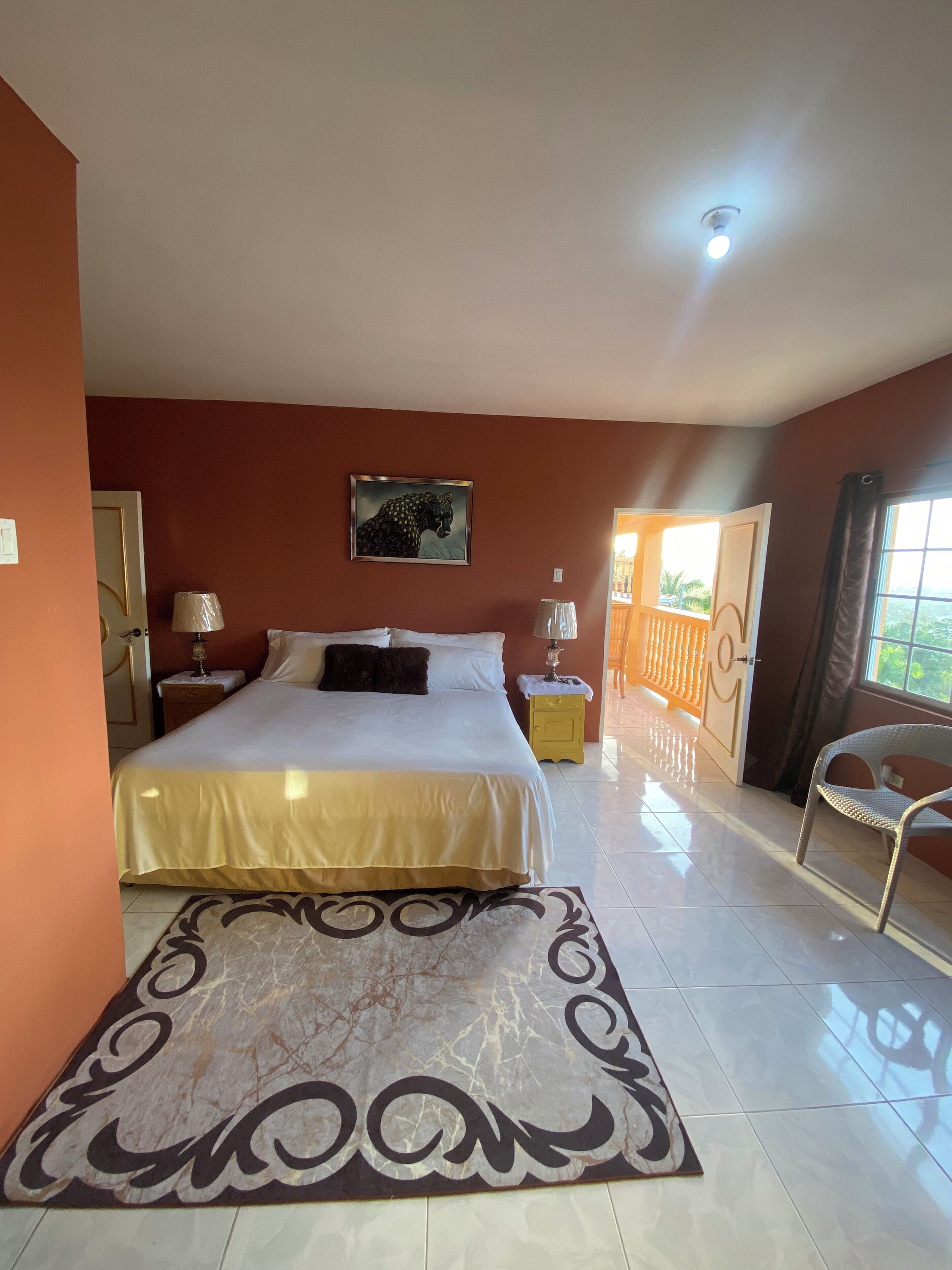 Une chambre à coucher avec un lit, des lampes de chevet, un tapis et un tableau au mur.