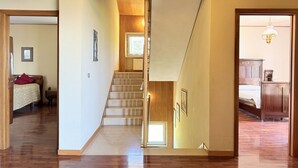 A staircase leading to a bedroom with a bed, a nightstand, and a dresser. - C015 – Camerano – Three-story villa with garden (Camerano)