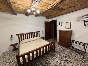 A bedroom with a wooden bed, a dresser, a mirror, and a ceiling fan.