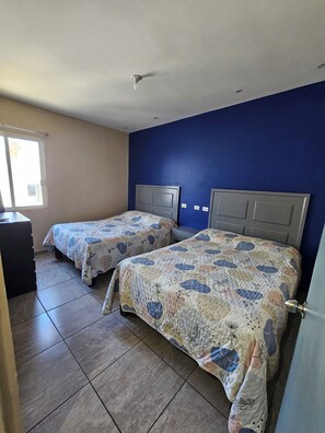 A room with two beds, a window, and a desk. - 2 min from the beach, centrally located and with pool access (San Carlos)