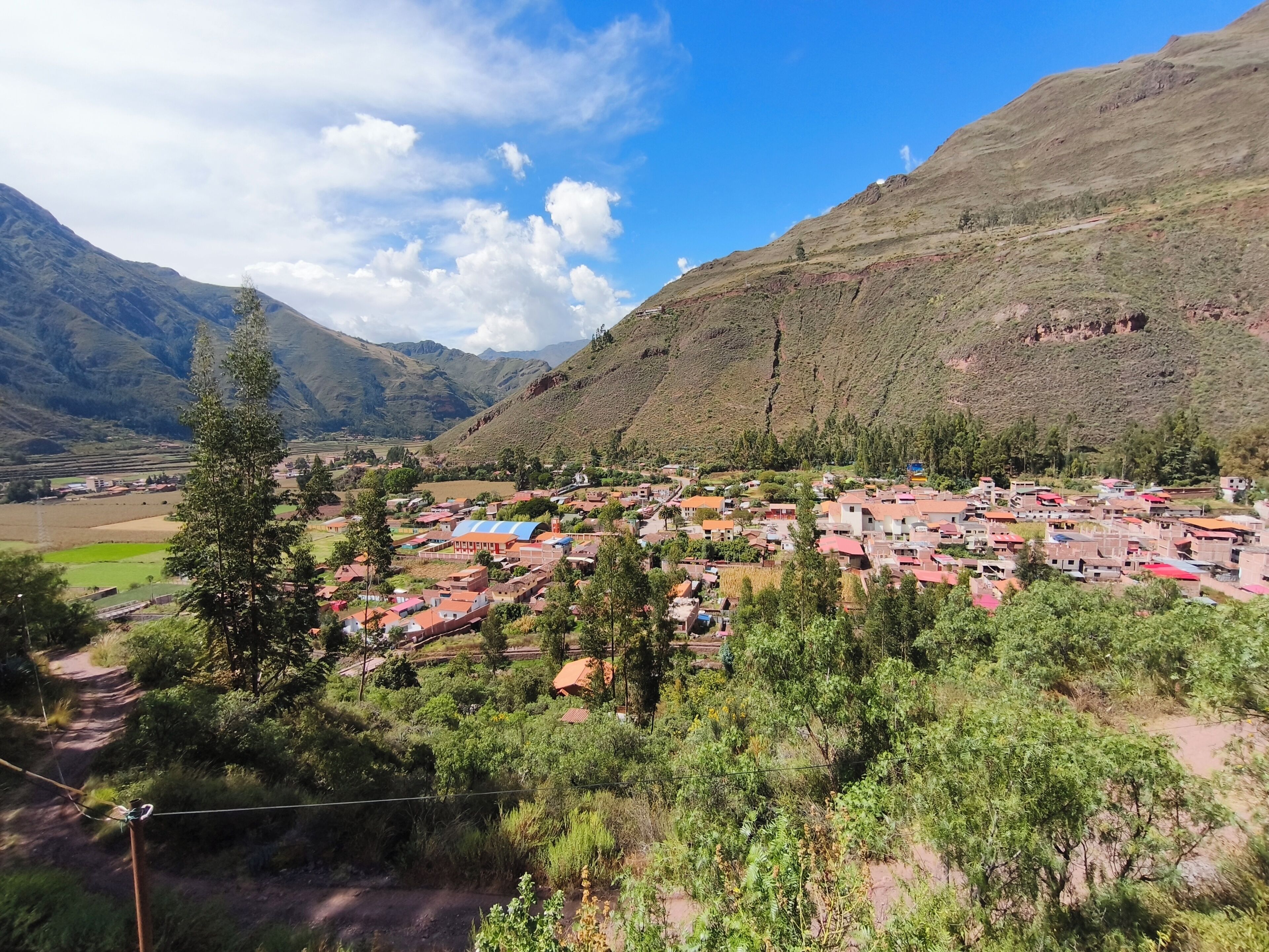 A mountainous village with houses, a clear sky, and a river.