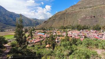 A mountainous village with houses, a clear sky, and a river.