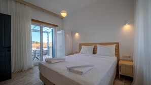 A hotel room with a large bed, a wooden headboard, a nightstand, a sliding glass door to an outdoor area, and a ceiling light. - Mia Storia Alaçatı Hotel (Cesme)