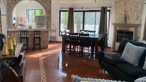 Ein Wohnzimmer mit Kamin, Essbereich und Küche mit Steinwänden und einem steinernen Bogen.