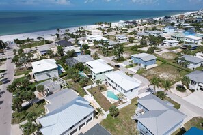 Luftaufnahme einer Küstenwohngegend mit Häusern, einem Strand und freiem Blick auf den Ozean.