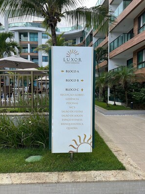 Ein Schild mit einer Auflistung der Annehmlichkeiten, darunter eine Lobby, ein Fitnessraum und ein Schwimmbad, an einem Hotel namens LUXOR.