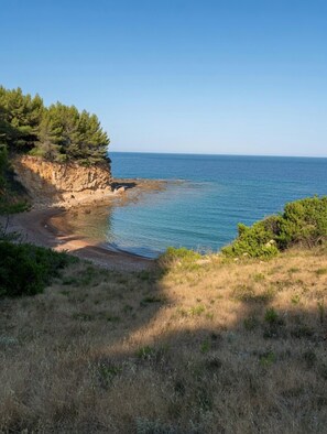 A coastal landscape with a clear sky, a rocky cliff, and a beach. - Modern Beachfront Villa ideal for families in Kotsikia Beachn N.Euboea (Evia)! (Kotsikia)