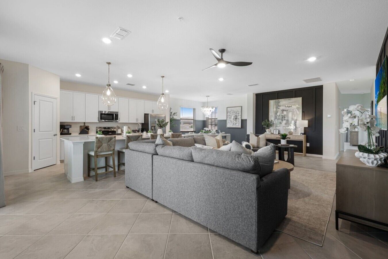 A modern kitchen with white cabinets, a central island, and pendant lighting.