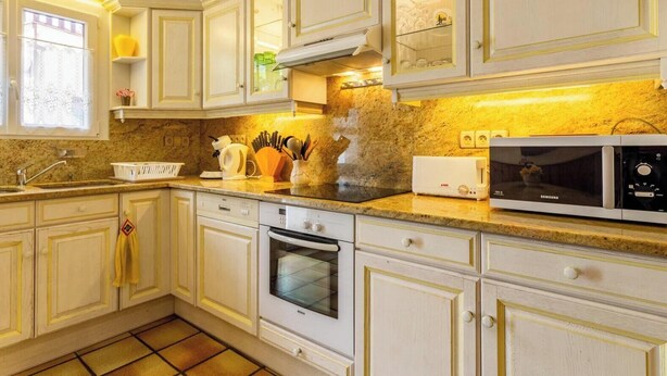 Cozinha com armários brancos, forno Bosch, micro-ondas Samsung e bancada de granito.