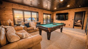 A cozy room with a pool table, leather sofa, and a television. - Blue Ridge Wellness Reset · Mirror Dome · Sauna · Cold Plunge · Long Range Views (Mineral Bluff)