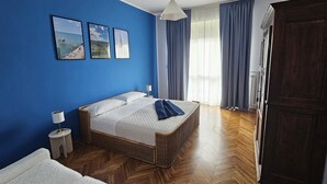 A bedroom with a bed, a nightstand, a lamp, a wardrobe, and a window with curtains. - CASA GB - Your home in the center of Turin (Torino)