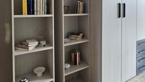 A room with a built-in bookshelf, a wardrobe with a mirror, and a small round table. - CASA GB - Your home in the center of Turin (Torino)