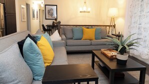A living room with a sofa, coffee table, and a potted plant. - Fabulous 5-bedroom house with AC in charming Chickamauga (Chickamauga)