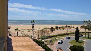 A residential area with a beach view, a paved road, and parked cars. - Alcaudón 86 - Two Bedroom Apartment, Sleeps 4 (Punta del moral)