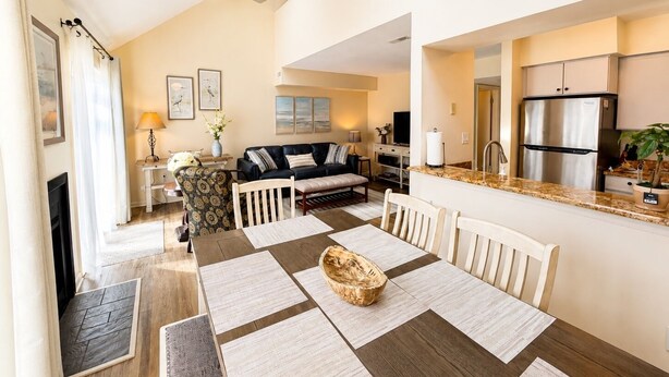 A modern kitchen with a built-in refrigerator, a dining area with a wooden table and chairs, and a living room with a sofa and artwork. - Upscale Rehoboth Retreat Minutes from Beach & Boardwalk (Rehoboth Beach)
