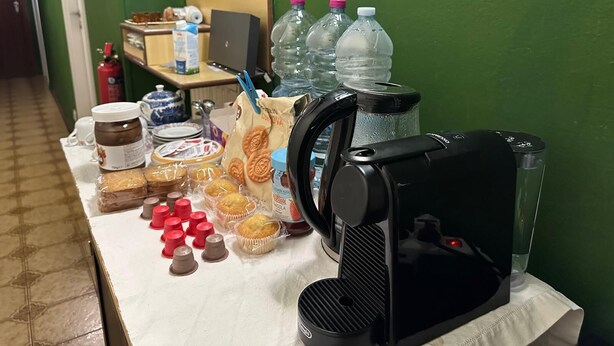Ein Tisch mit Speisen, einer Kaffeemaschine und Wasserflaschen.