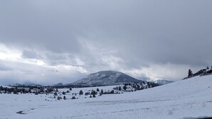 A snowy mountain landscape with a prominent peak, a valley with scattered trees, and a cloudy sky. - Cascade Valley Wonderland campground in Hornbrook perfect for outdoor adventures (HORNBROOK)