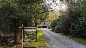 Un camino de grava que conduce a un edificio con un letrero de The Trailhead Chalet.