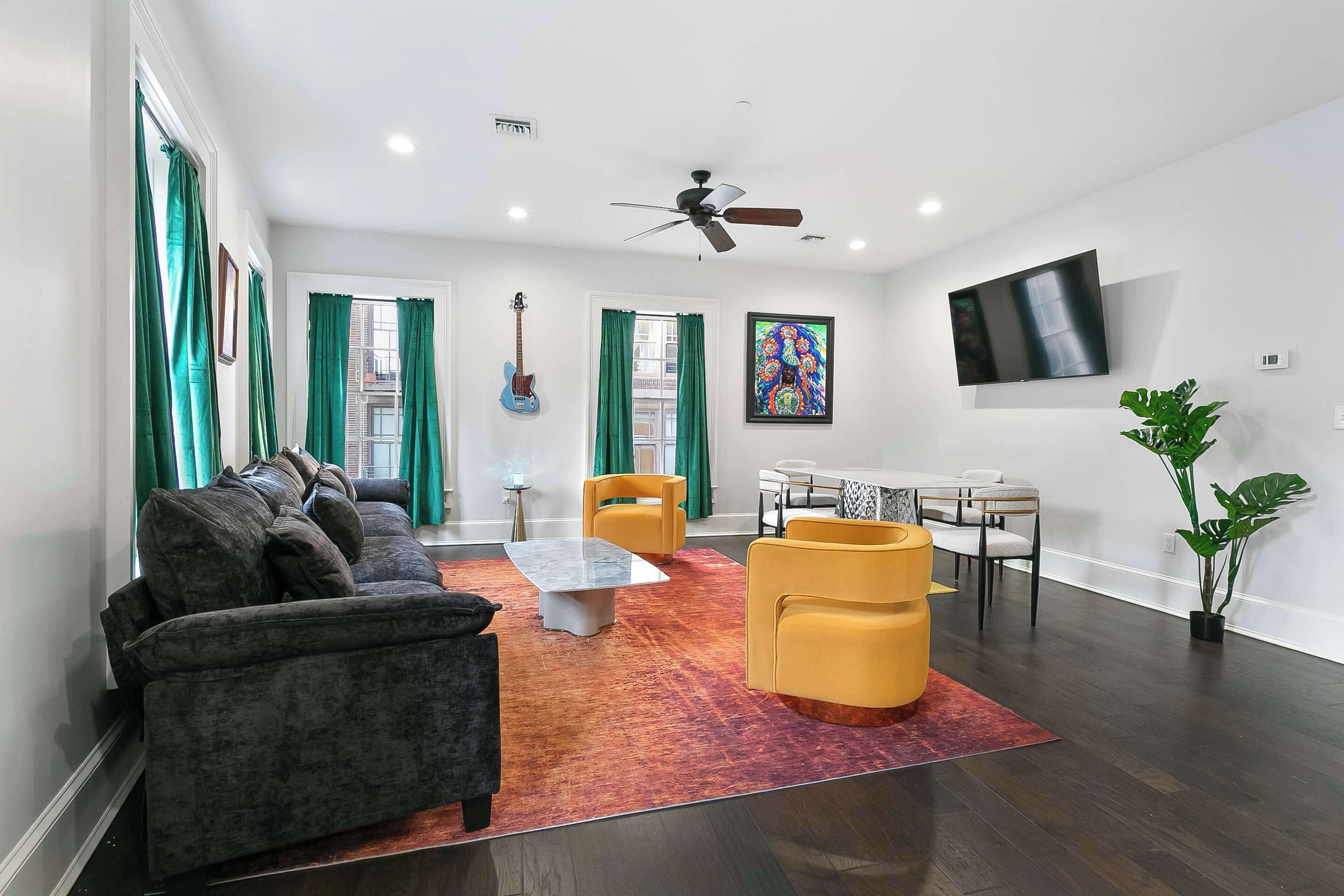 Step into the Funk Room featuring wall art by local artist Ayodele Owolabi, gallery-style décor, and real instruments that set the mood. Spacious living area with a marble table, comfy seating, smart TV, and Magazine Street views.