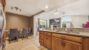 Une cuisine moderne avec des meubles en bois, un plan de travail en granit et un four encastré.