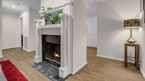 Una sala de estar moderna con chimenea, un tapete rojo y una lámpara.