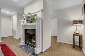 Ein modernes Wohnzimmer mit Kamin, einem roten Teppich und einer Lampe.