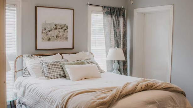 A bedroom with a bed, a ceiling fan, a framed picture on the wall, and a window with curtains. - Work Trip & Family Friendly - 3BR House in Historic Sayles. Long Term Stays (Abilene)