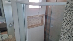 A modern bathroom with a glass shower enclosure, a sink, and a toilet.