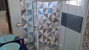 Chuveiro, toalhas de banho, sabonete, papel higiênico