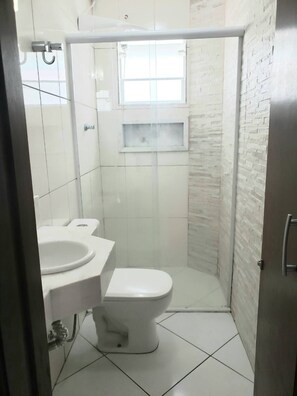 A small, modern bathroom with a toilet, sink, and shower. - Complete house with private backyard. (Mogi das Cruzes)