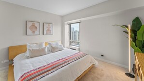 Un dormitorio con una cama, una ventana y una planta.