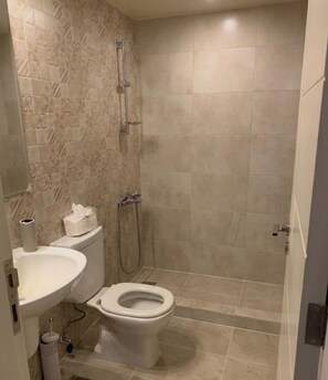 A bathroom with a toilet, sink, and shower.