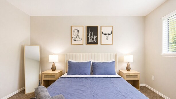 A bedroom with a bed, two bedside tables, a mirror, and three framed pictures on the wall. - 1bd, 1ba WORLD CUP Stay, Close to stadiums, Six Flags and UTA (Arlington)