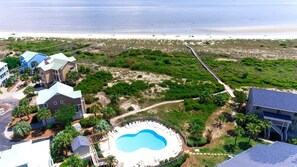 A coastal property with a swimming pool, beachfront access, and multiple buildings.